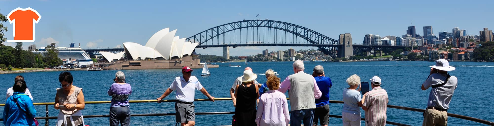 A Sydney sightseeing bus has stopped at Mrs Macquarie's Point, where tourists are taking pictures of the Sydney Opera House and Sydney Harbour Bridge in the background.
