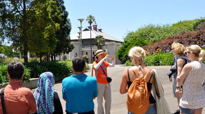  A group of tourists on a Sydney walking in front of the former government stables