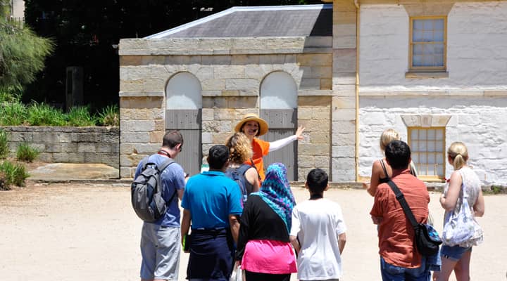 Tourists at the West Circular Quay listening to a tour guide in orange free tours uniform.